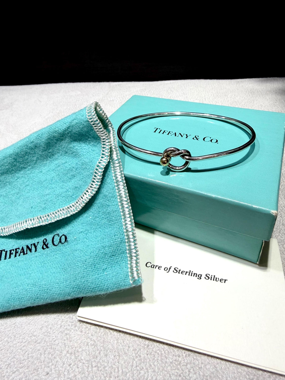 Tiffany & Co. 18K Gold Heart Love Knot Twist Sterling Silver Bangle Bracelet 925 750 with Box, Pouch, and Care Card.