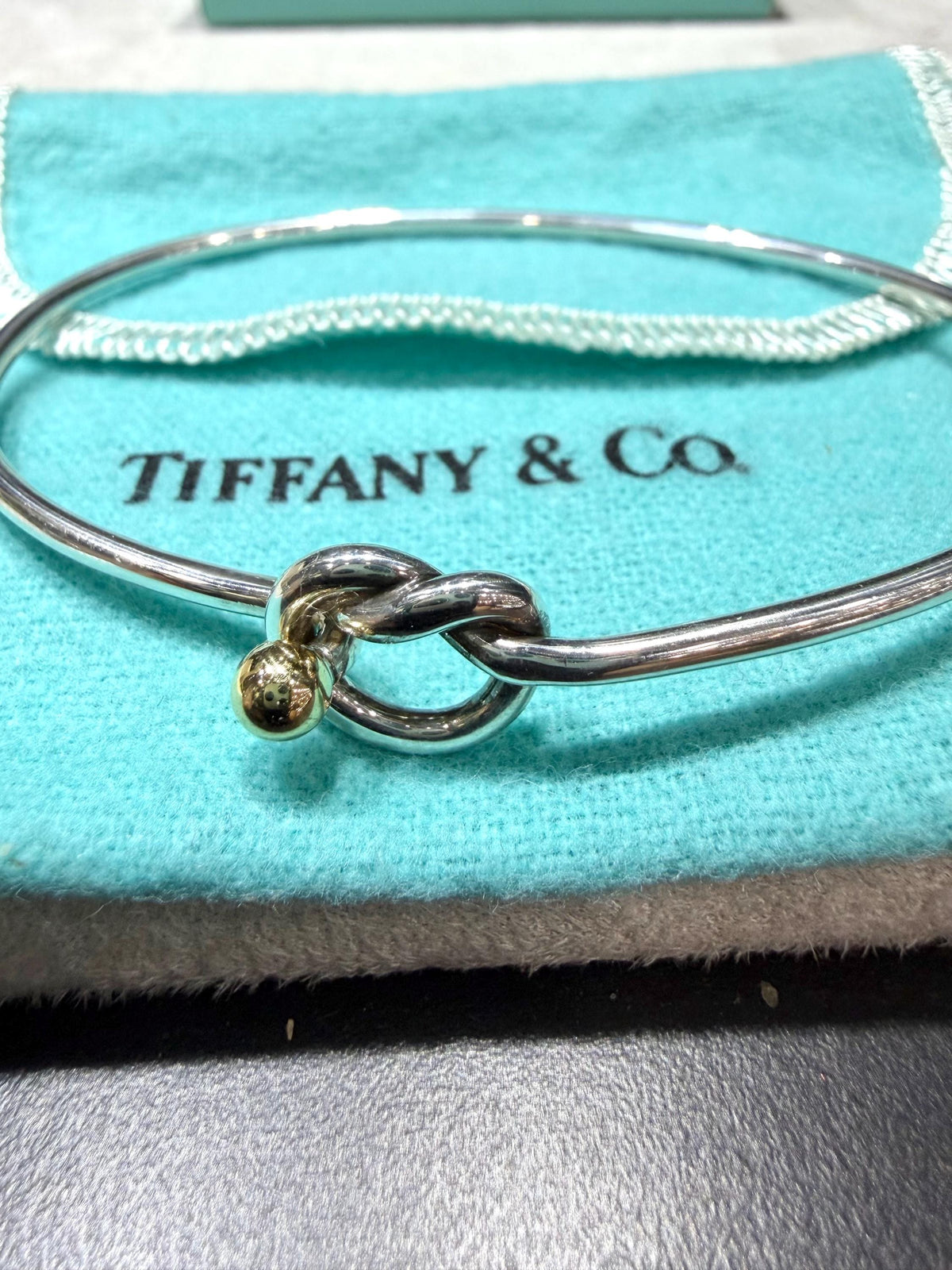 Tiffany & Co. 18K Gold Heart Love Knot Twist Sterling Silver Bangle Bracelet 925 750 with Box, Pouch, and Care Card.