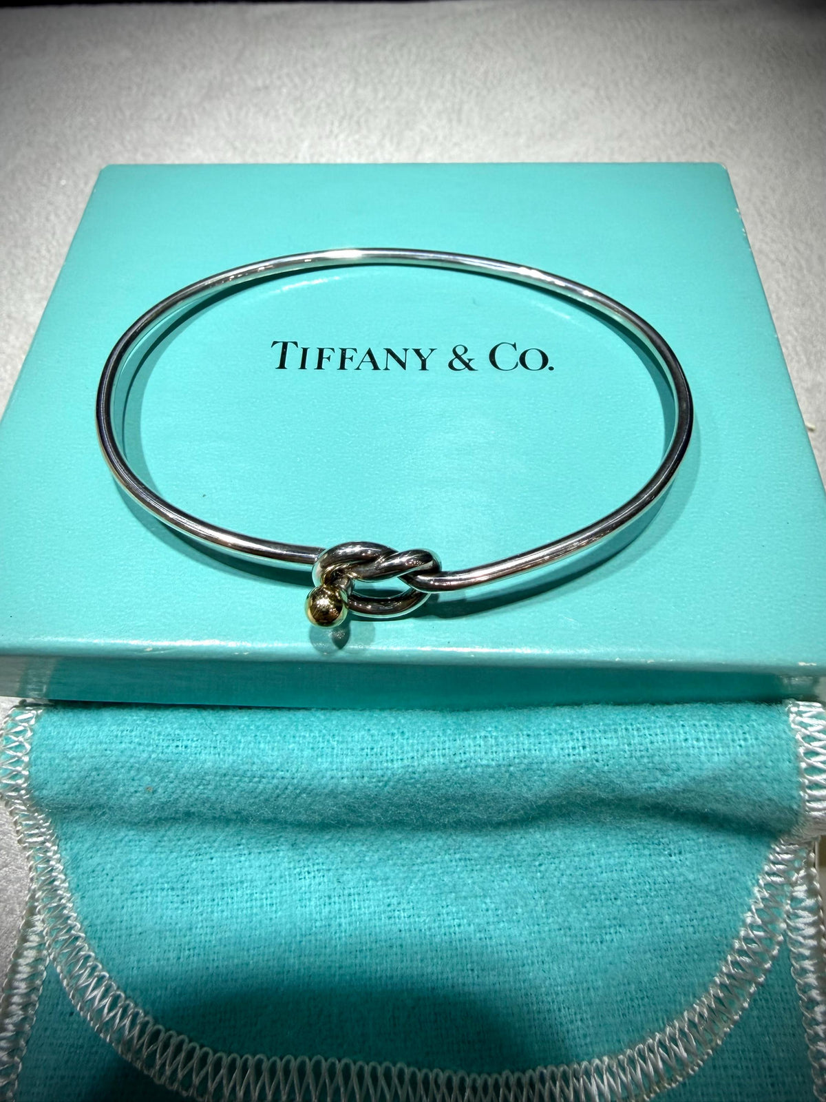 Tiffany & Co. 18K Gold Heart Love Knot Twist Sterling Silver Bangle Bracelet 925 750 with Box, Pouch, and Care Card.